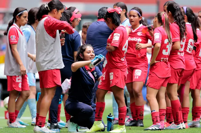 La doctora atiende a una jugadora del Toluca Femenil durante una pausa del partido